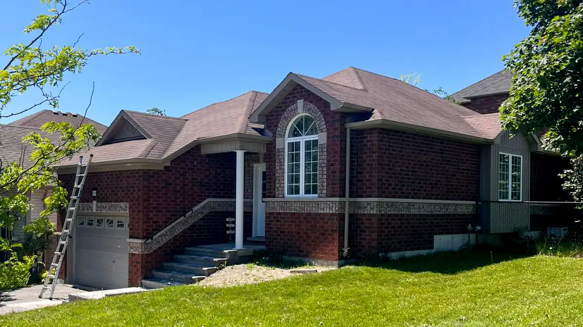 Freshly installed architectural asphalt shingle roof on a two-tone brick bungalow in Peterborough