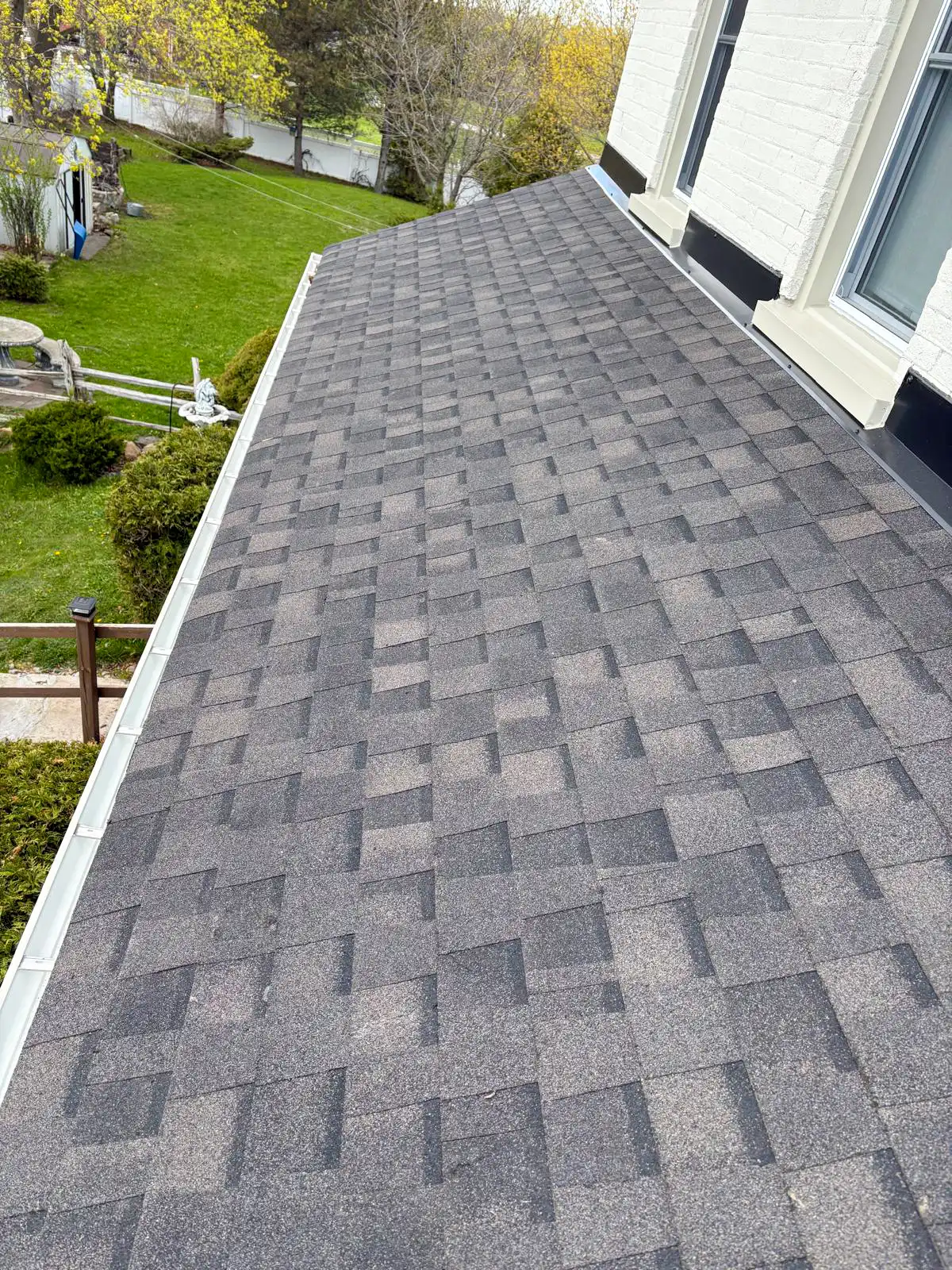 Charcoal architectural asphalt shingles with new eavestrough on a completed Bullarco roof