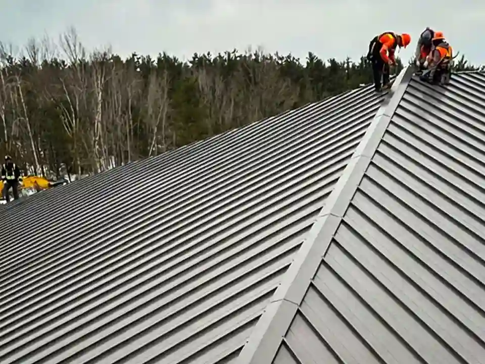Bullarco crew working on a standing seam metal roof ridge