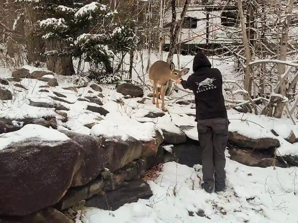 Bullarco crew member in a branded hoodie on a snowy property