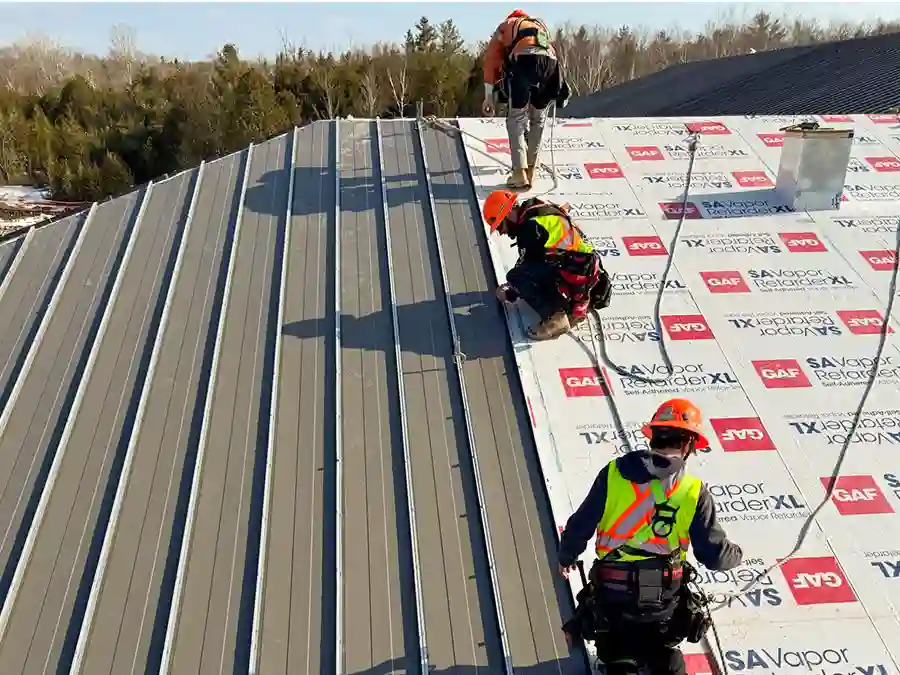 Bullarco crew installing metal roofing panels on a large roof