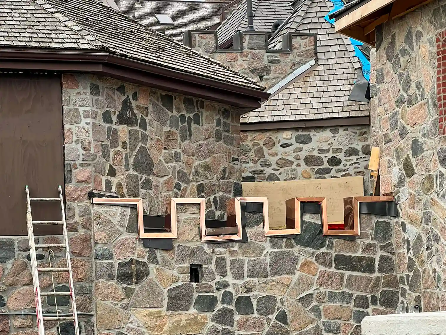 Custom copper window surrounds installed on a heritage stone home