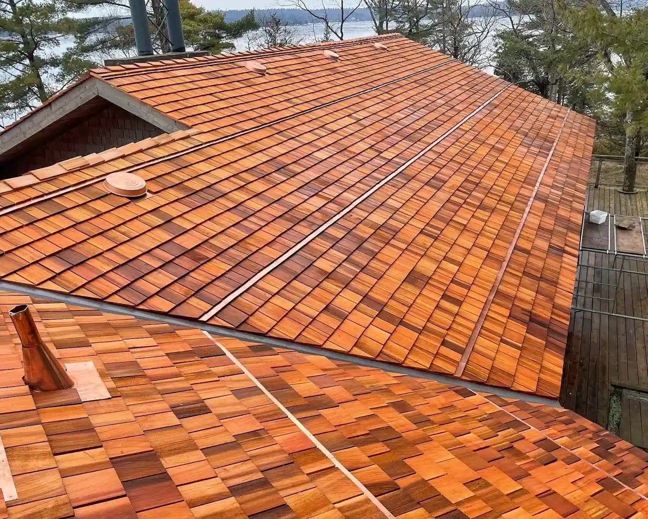 Aerial view of cedar shingles with copper vent caps and valley liners at a Kawartha Lakes property