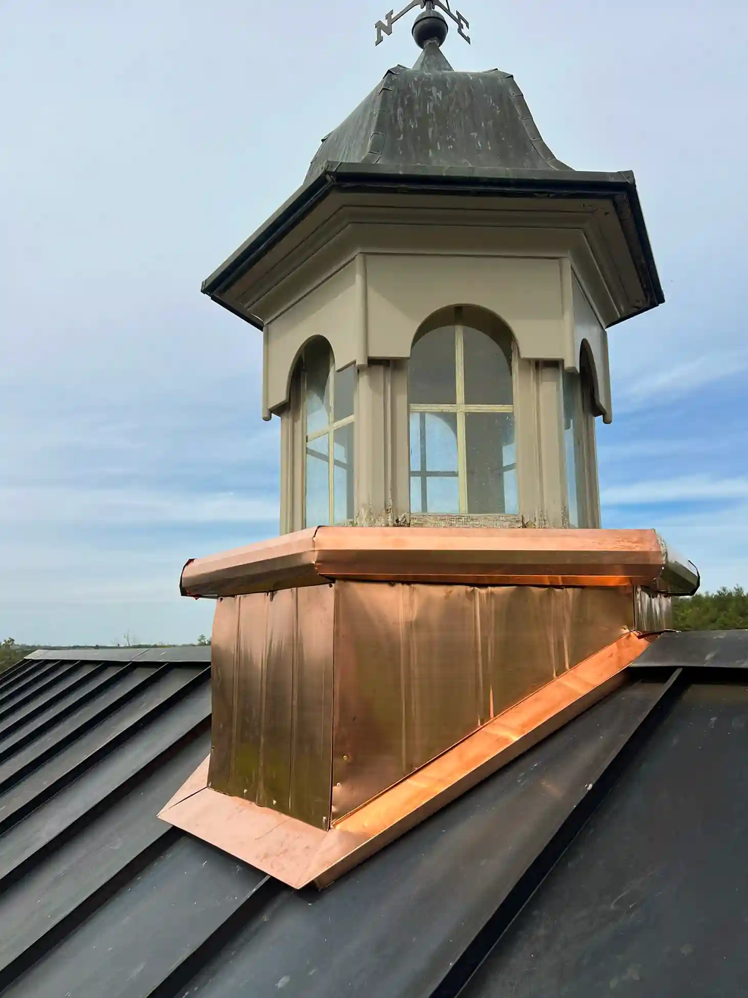 Freshly installed copper cupola base on a standing seam metal roof