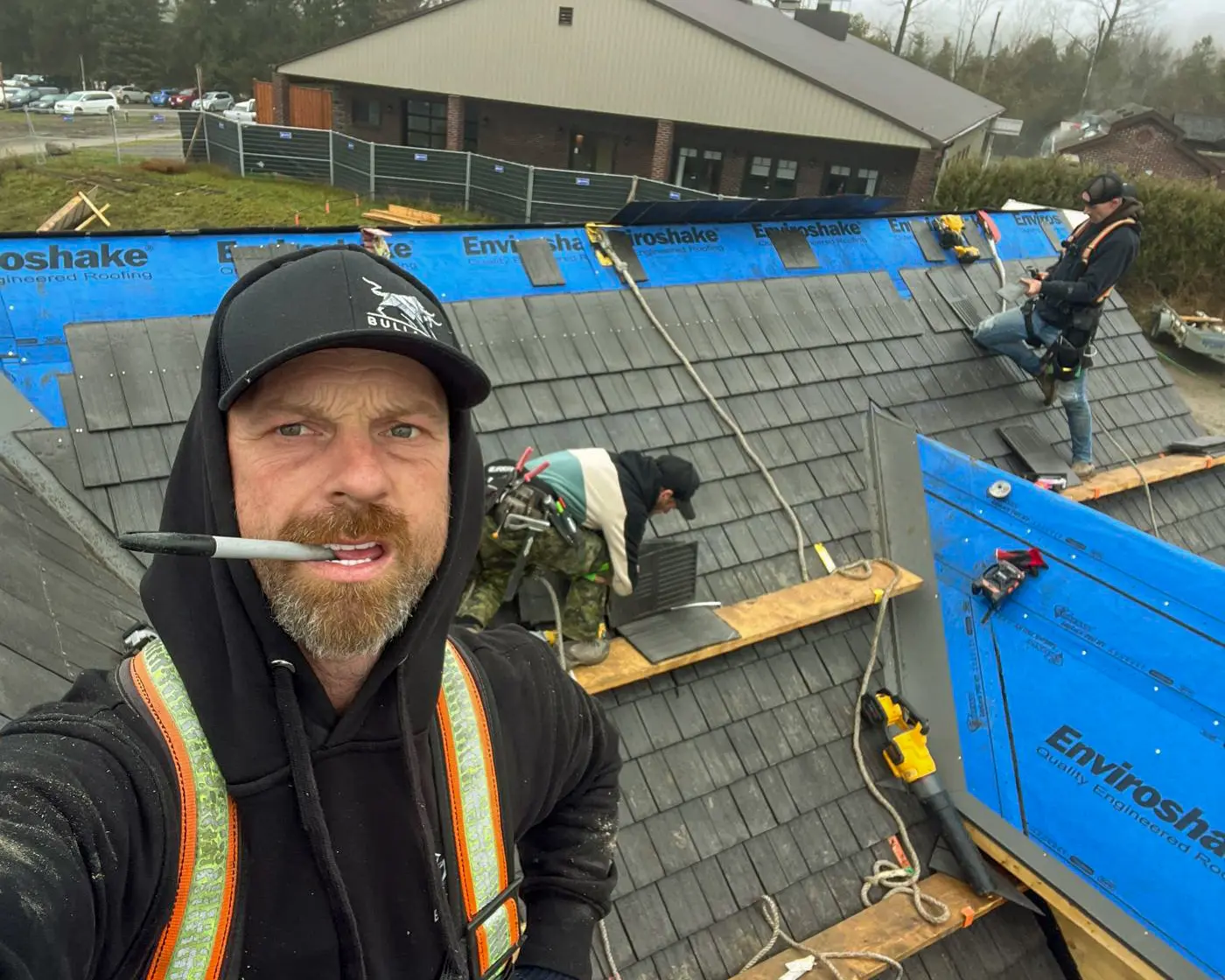 Bullarco roofing crew installing Enviroshake composite shakes over branded underlayment